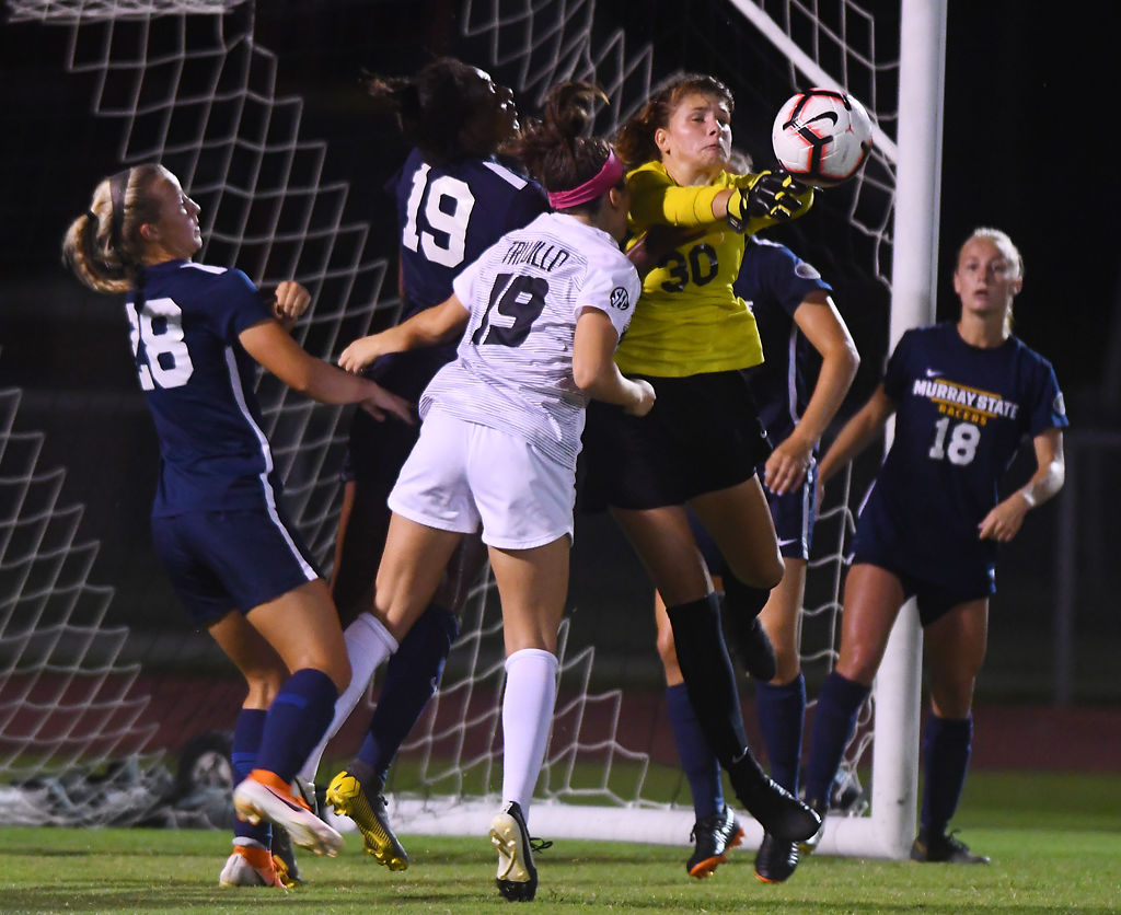 Jenna Villacres stretches in mid-air for the ball while surrounded by her defenders and Macy Trujillo